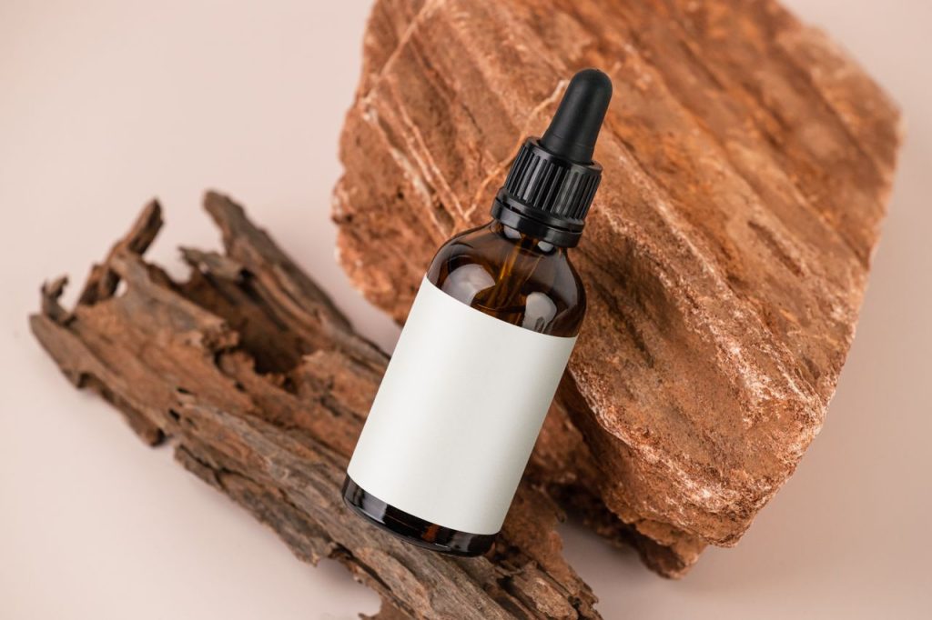 Produits Minimalist image of a brown dropper bottle with a blank label on rustic wood, ideal for natural products.